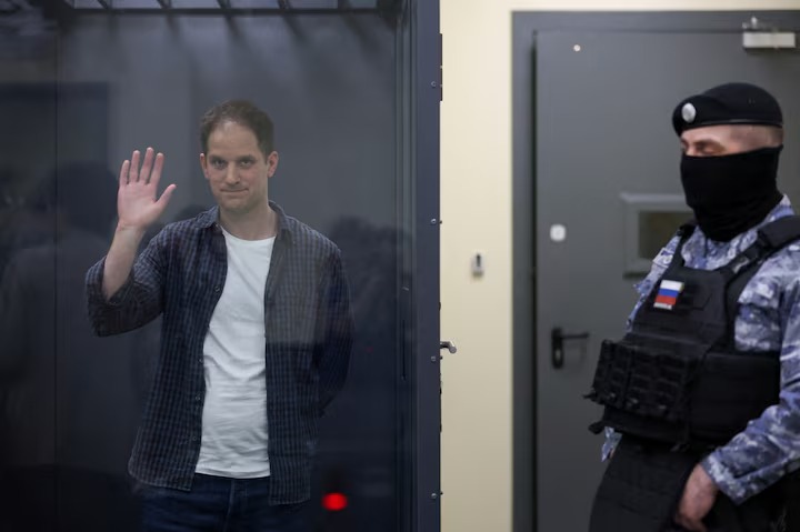 Wall Street Journal reporter Evan Gershkovich, who is in custody on espionage charges, waves behind a glass wall of an enclosure for defendants as he attends a court hearing in Moscow, Russia, April 23, 2024. (Reuters) Wall Street Journal reporter Evan Gershkovich, who is in custody on espionage charges, waves behind a glass wall of an enclosure for defendants as he attends a court hearing in Moscow, Russia, April 23, 2024. (Reuters)