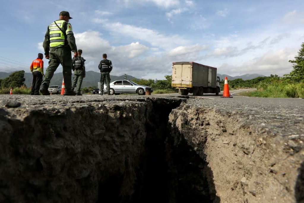 Members of the Bolivarian National Guard of Venezuela stand on a road cracked after two strong earthquakes, in Moron, Venezuela, June 25, 2026. REUTERS/Juan Carlos Hernandez