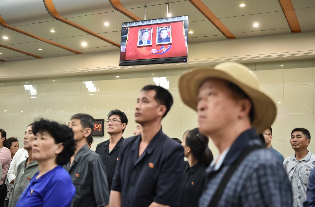 Photo by KIM WON JIN / AFP  People watch a news program on the visit of China's President Xi Jinping, in the Kaeson Station of the Pyongyang Metro in Pyongyang on June 9, 2026.