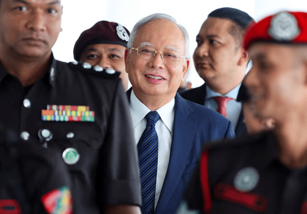 Prison officers escort former Malaysian Prime Minister Najib Razak, as the jailed politician leaves the court during a break in proceedings, in Kuala Lumpur, Malaysia, April 4, 2024. REUTERS/Hasnoor Hussain/File Photo