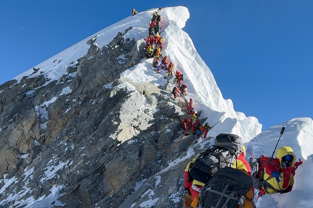 This photograph taken on May 20, 2026, shows mountaineers climbing a slope lined up during their ascent from the Hillary Step to summit Mount Everest in Nepal. (Photo by Furte Sherpa / AFP)