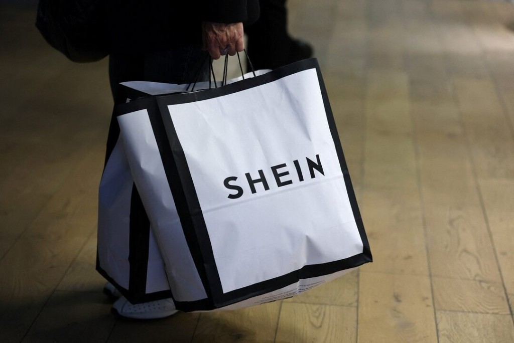 A customer holds shopping bags with a Shein logo in the first physical space of Chinese online fast-fashion retailer Shein on the day of its opening inside the Le BHV Marais department store, the Bazar de l'Hotel de Ville, in Paris, France, November 5, 2025. REUTERS/Sarah Meyssonnier 