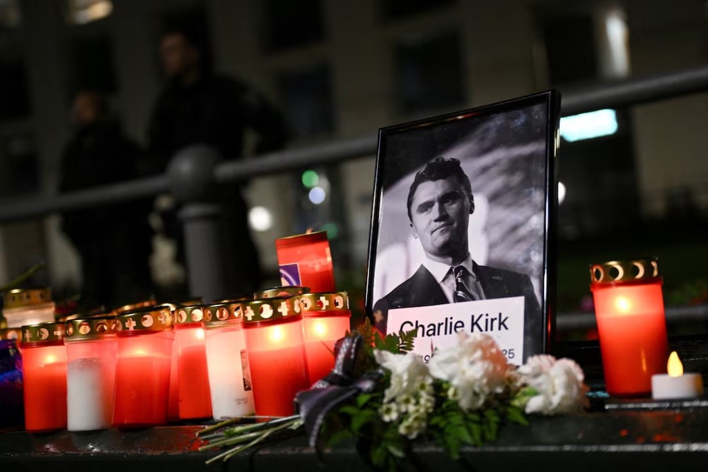 Roses and candles are placed next to a picture of Charlie Kirk during a vigil under the line "In Memory of Charlie Kirk, for freedom, patriotism and justice" in front of the Embassy of the United States after U.S. right-wing activist, commentator, Charlie Kirk, an ally of U.S. President Donald Trump, was shot dead during an event at Utah Valley University, Orem, U.S., in Berlin, Germany September 11, 2025. REUTERS/Annegret Hilse
