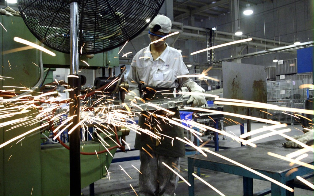 A welder works at the Auto Parts Alliance (China) factory in Guangdong, a Japanese company who supplies parts for Honda, 14 June 2003. AFP