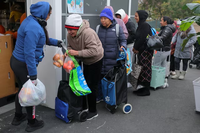 Workers distribute groceries at La Colaborativa’s food pantry, as food aid benefits, including SNAP payments, will be suspended starting November 1 amid the ongoing U.S. government shutdown, in Chelsea, Massachusetts, U.S., October 29, 2025. REUTERS/Brian Snyder