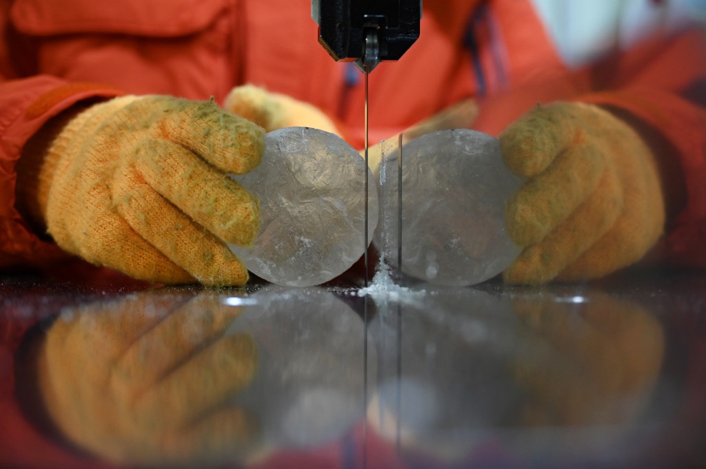 Photo by GREG BAKER / AFP  A researcher cuts a slice from an ice core sample taken from a glacier in the Pamir mountain range in Tajikistan, at the Hokkaido University Institute of Low Temperature Science, in Sapporo, in northern Japan’s Hokkaido prefecture on December 9, 2025.