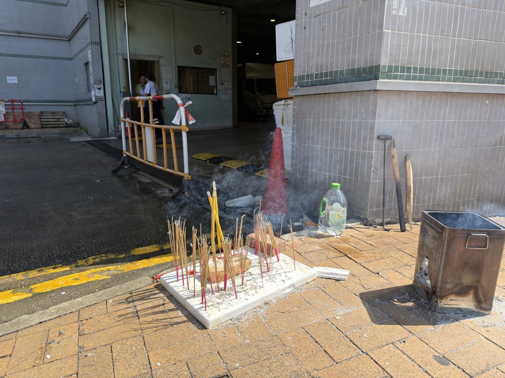 Candles and incense were lit to pay respects to the deceased elderly woman and her domestic helper.