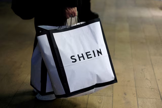 A customer holds shopping bags with a Shein logo in the first physical space of online fast-fashion retailer Shein on the day of its opening inside the Le BHV Marais department store, the Bazar de l'Hotel de Ville, in Paris, France, November 5, 2025. REUTERS/Sarah Meyssonnier/File Photo 