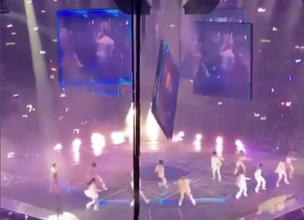 In this image made from video taken from social media, a massive video screen suspended above the stage fells onto performers at a concert of Cantopop boy band Mirror, in Hong Kong, Thursday, July 28, 2020. Two dancers were injured at a Cantopop concert in Hong Kong after a massive video screen suspended above the stage fell onto performers below. (AP Photo) 