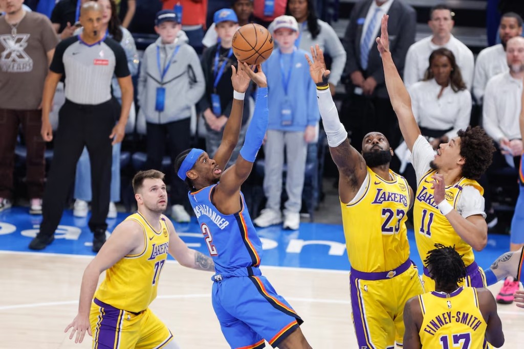 Oklahoma City Thunder guard Shai Gilgeous-Alexander (2) shoots as Los Angeles Lakers forward LeBron James (23) and center Jaxson Hayes (11) defend the shot during the first quarter at Paycom Center. (Reuters)