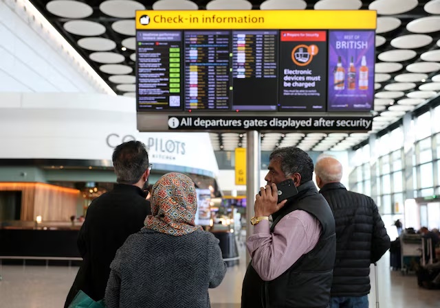 Travellers check on a departure board displaying cancelled flights to Middle East countries amid the U.S.-Israel conflict with Iran, at Heathrow Airport Terminal 4, in Greater London, Britain, March 2, 2026. REUTERS/Isabel Infantes/File Photo