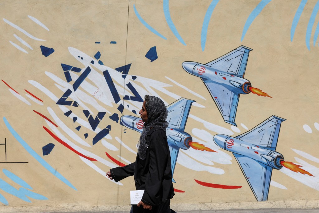 An Iranian woman walks past an anti-Israeli mural, after U.S. and Iranian officials said they had reached a deal to end their war and reopen the Strait of Hormuz, in Tehran, Iran, June 15, 2026. Majid Asgaripour/WANA (West Asia News Agency) via REUTERS