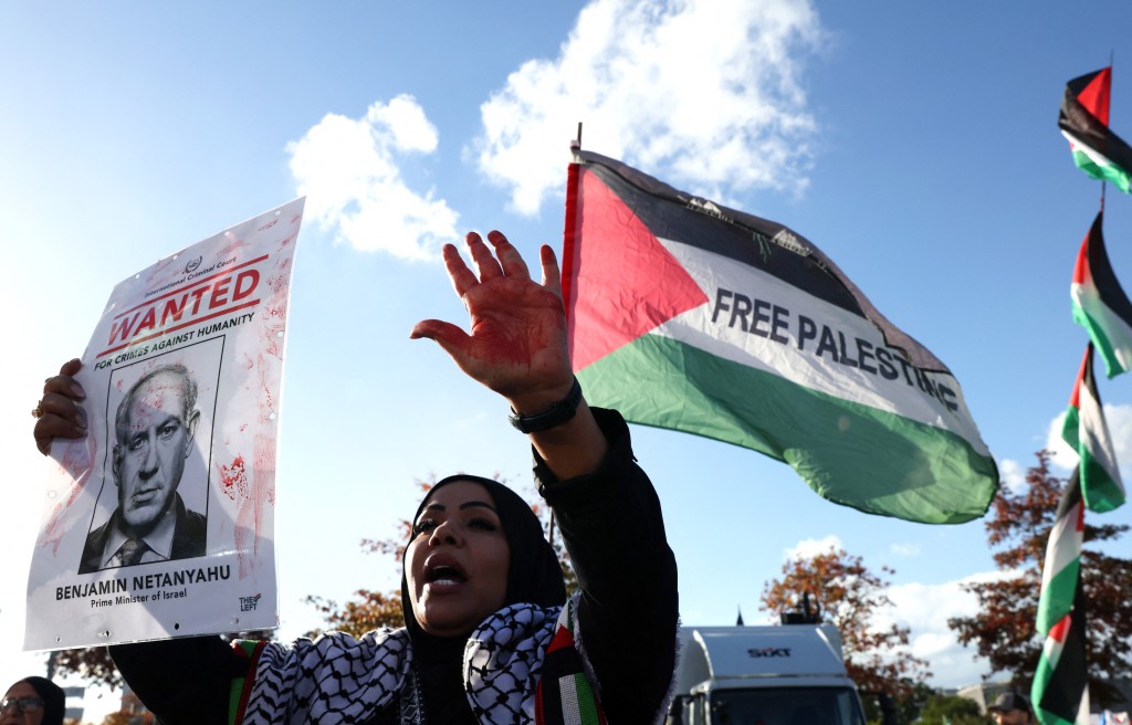 An participant holds a 'Wanted' poster of Israel's Prime Minister Benjamin Netanyahu during a pro-Palestinian demonstration under the title 'United4Palestine' in Berlin on October 10, 2026. (Photo by Adam BERRY / AFP)