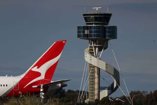A Qantas plane passes an air traffic control tower as it taxis along a runway Sydney Airport, in Sydney, Australia, August 21, 2026. REUTERS/Hollie Adams