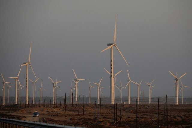 A car drives near wind turbines on a power station near Yumen, Gansu province, China September 29, 2020. Picture taken September 29, 2020. REUTERS/Carlos Garcia Rawlins
