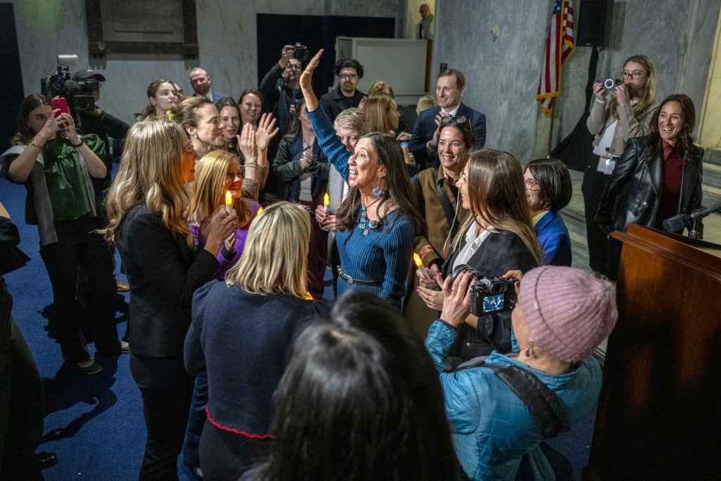 Photo by DANIEL HEUER / AFP  US congresswoman Teresa Leger Fernandez (C), Democrat of New Mexico, celebrates with victims of convicted sex offender Jeffrey Epstein, after announcing to attendees of a candlelight vigil, that the US Senate passed the "Epstein Files Transparency Act" in Washington, DC on November 18, 2025.
