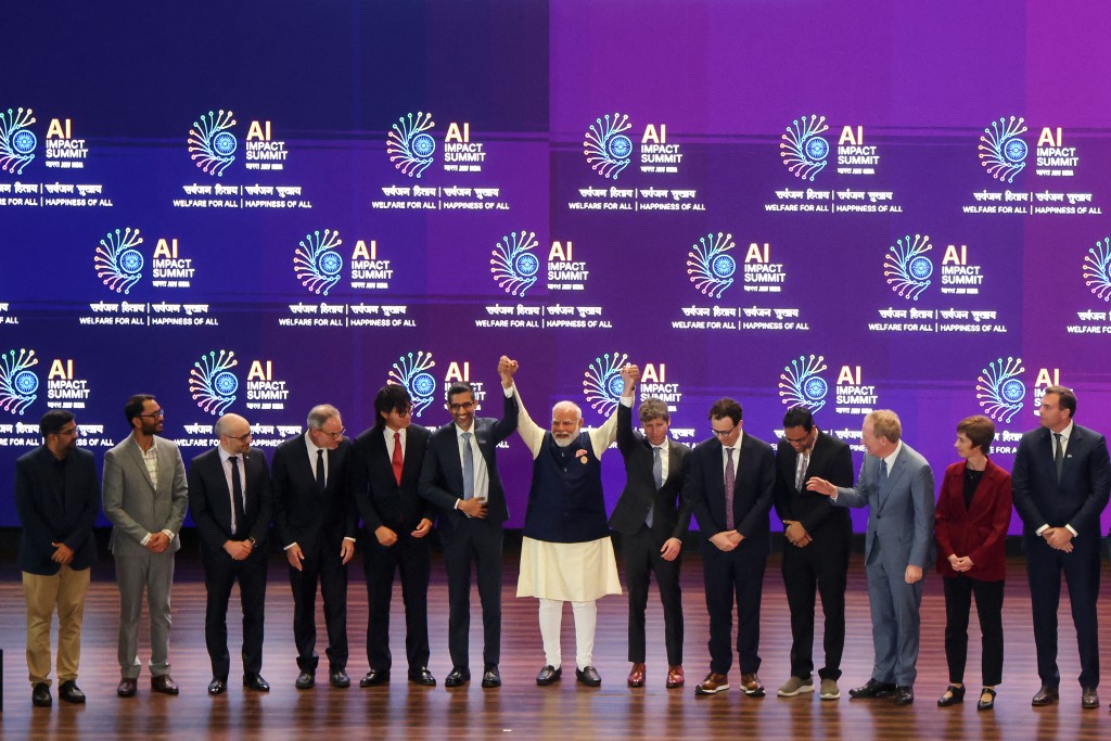 TOPSHOT - India's Prime Minister Narendra Modi (C) takes a group photo with AI company leaders at the AI Impact Summit in New Delhi on February 19, 2026. (Photo by Ludovic MARIN / AFP)