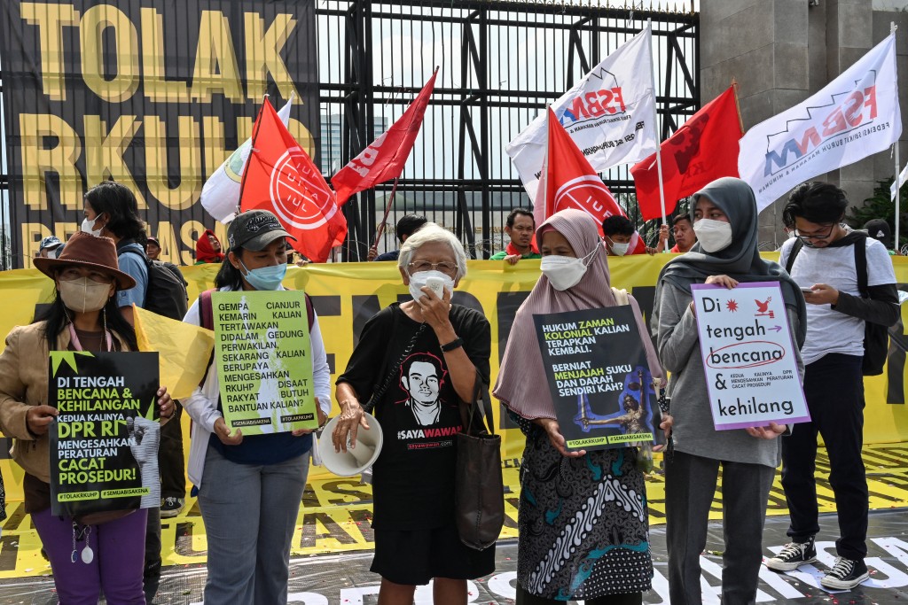 Photo by ADEK BERRY / AFP  This picture taken on December 5, 2022 shows activists holding a protest against the new criminal code outside the parliament building in Jakarta.