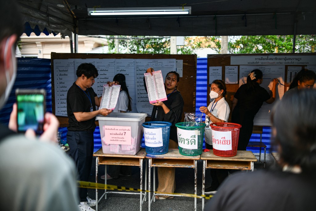 People watch as votes in Thailand's general election are counted at a polling station in Bangkok on February 8, 2026. (AFP)