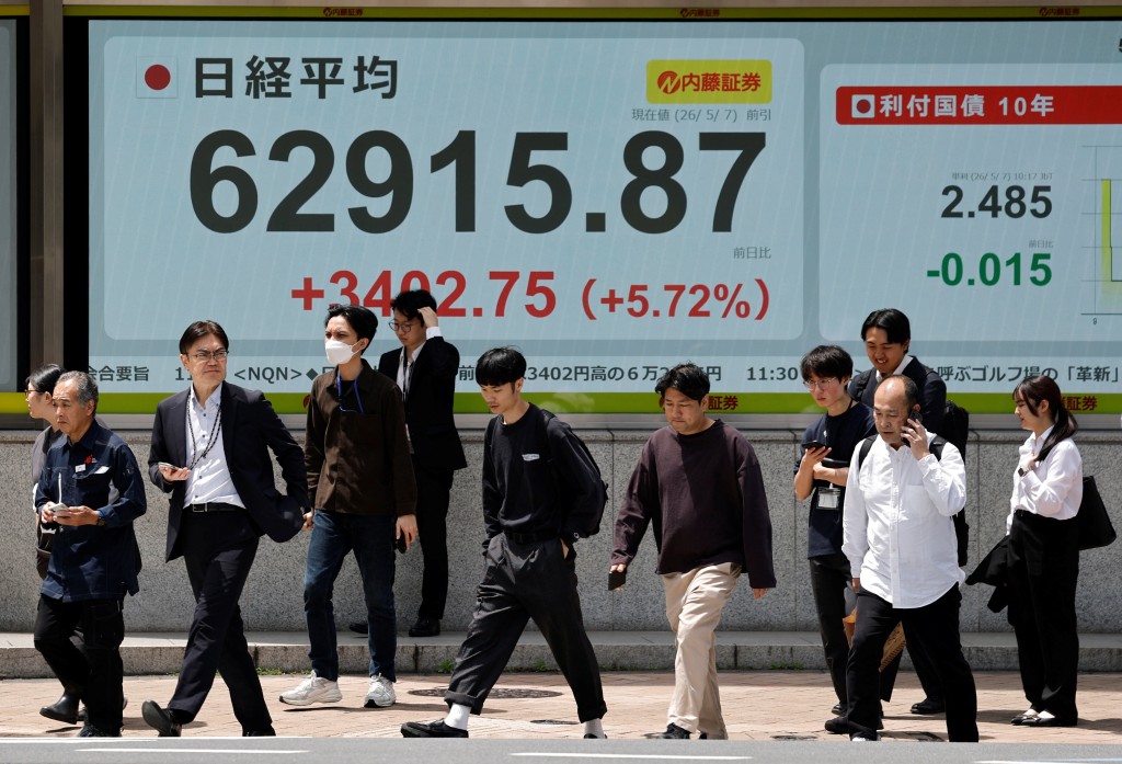 Pedestrians walk past a stock quotation board showing the Nikkei share average outside a brokerage in Tokyo, Japan, May 7, 2026. REUTERS