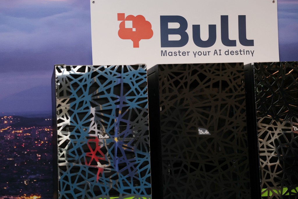 A photo shows a company logo over supercomputer cabinets at the site of IT company Bull in Les-Clayes-sous-Bois on April 3, 2026. Bull, which manufactures supercomputers among other products, announced its plan to hire 500 people in 2026, mainly in Europe, after being acquired by the French government and spun off from the Atos group. (Photo by Thomas SAMSON / AFP)