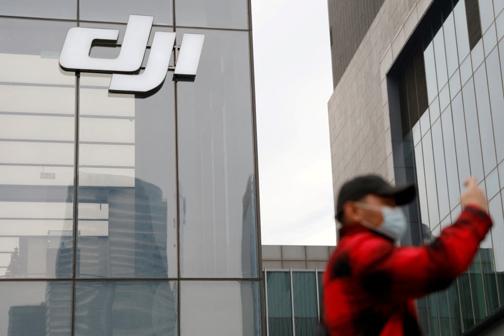 A man stands outside a store of Chinese drone maker DJI in Beijing, China December 15, 2021. REUTERS