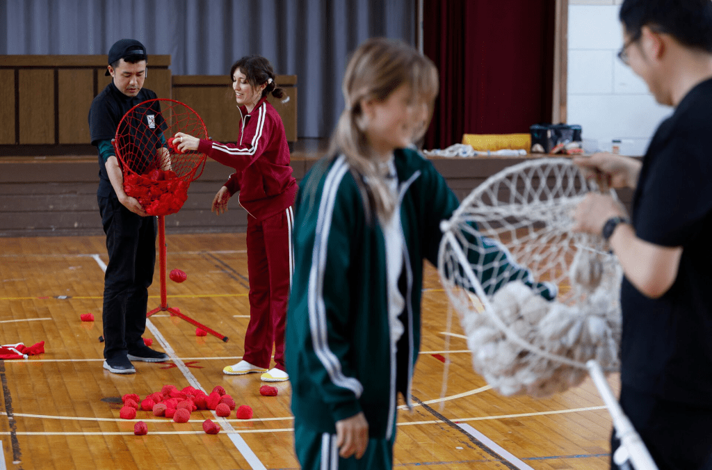 Tourists from abroad wearing sport uniforms play "beanbag toss" during sports class, while taking part in a Japanese high school experience in Kimitsu, Chiba prefecture, Japan April 23, 2025. REUTERS/Manami Yamada 