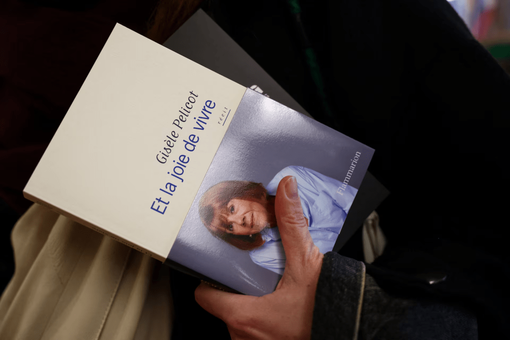 A customer holds a copy of the book "Et la joie de vivre" (A Hymn to Life: Shame Has to Change Sides) by French mass rape survivor Gisele Pelicot, a book written with journalist and novelist Judith Perrignon, in the Les Getteurs de vents bookstore in Paris, France, February 17, 2026. REUTERS/Sarah Meyssonnier