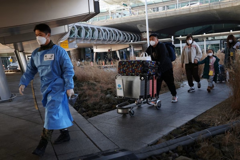 A South Korean soldier wearing personal protective equipment (PPE) leads a group of Chinese tourists to the coronavirus disease (Covid-19) testing center upon their arrival at the Incheon International Airport. (Reuters) A South Korean soldier wearing personal protective equipment (PPE) leads a group of Chinese tourists to the coronavirus disease (Covid-19) testing center upon their arrival at the Incheon International Airport. (Reuters)