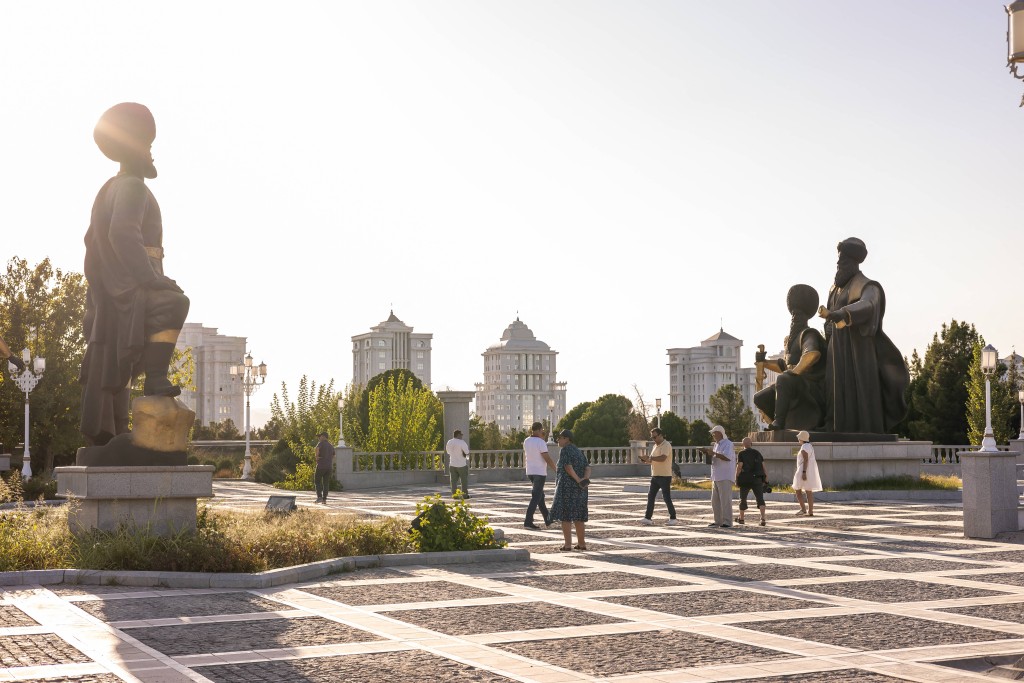(FILES) People walk in front of Independence Monument in central Ashgabat on August 9, 2025. (Photo by STRINGER and STRINGER / AFP)
