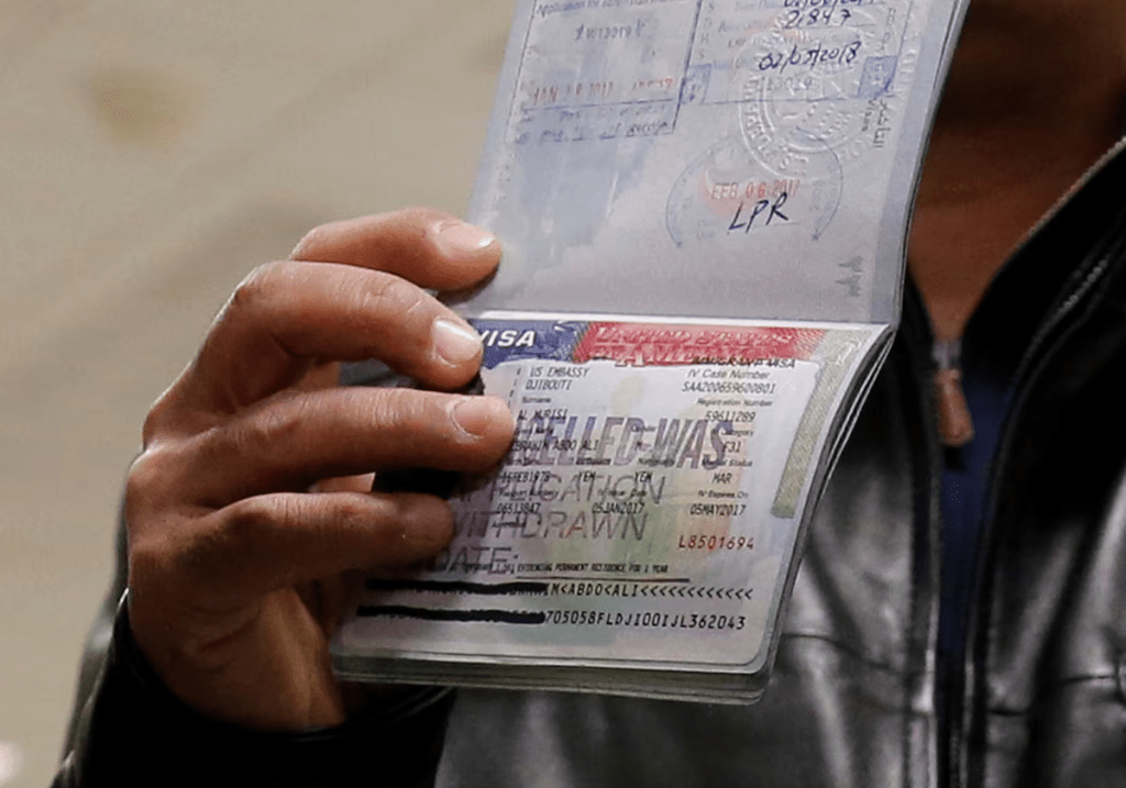 A person shows a cancelled visa in their passport, at Washington Dulles International Airport in Chantilly, Virginia, U.S. February 6, 2017. REUTERS/Jonathan Ernst/File Photo
