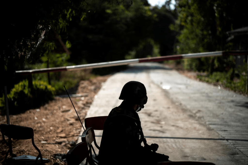 A Thai soldier sits in front of the blockage of a road leading to the Thailand-Myanmar border where the fighting between the Myanmar army and ethnic minority rebels still continues in Mae Sot district, Tak province, Thailand, December 19, 2021. REUTERS/Athit Perawongmetha/File Photo