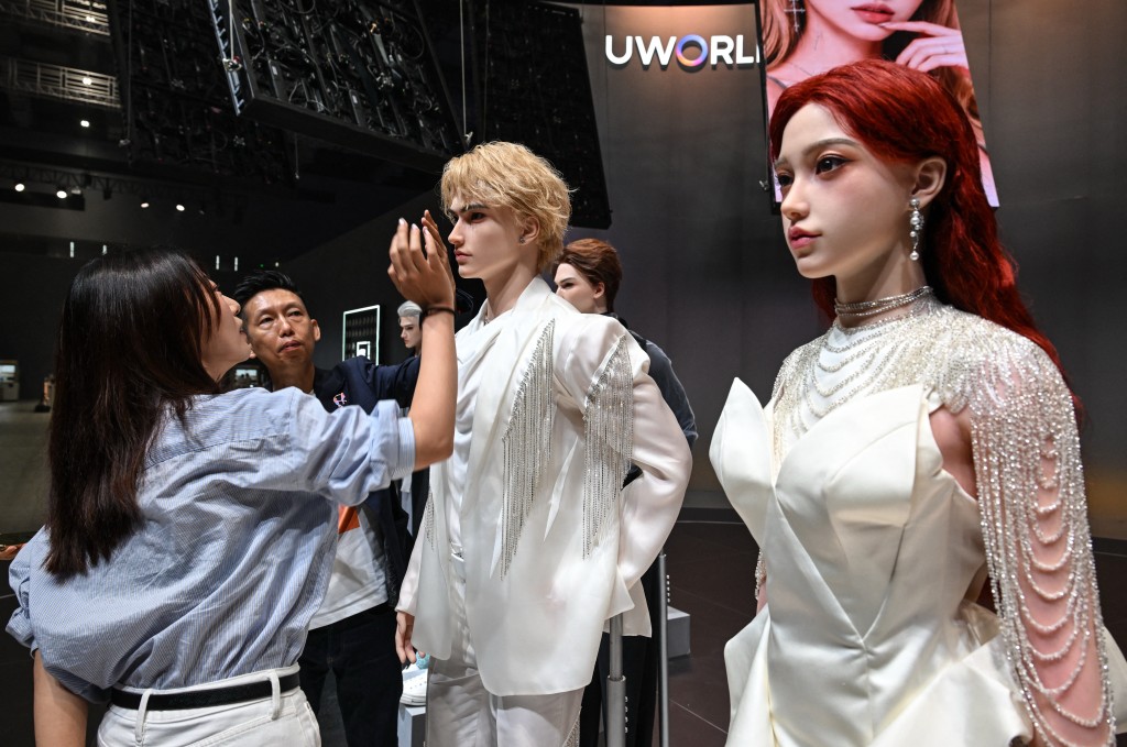 Photo by ADEK BERRY / AFP  CEO of UWORLD Michael Tam (2nd L) presents a humanoid robot to a visitor during the launch of the U1 humanoid robot produced by UWORLD, a brand under UBTECH Robotics, in Shenzhen, China's Guangdong province on June 30, 2026.