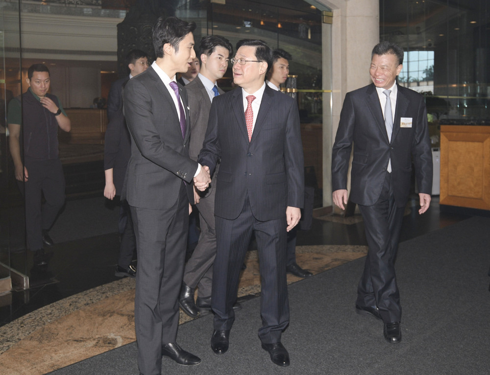 John Lee, center, is greeted on his arrival at the forum by Karson Choi, left, and Kwok Ying-shing. SING TAO John Lee, center, is greeted on his arrival at the forum by Karson Choi, left, and Kwok Ying-shing. SING TAO