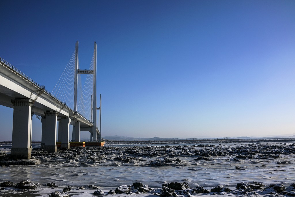 Photo by CHANDAN KHANNA / AFP In this photo taken on January 11, 2018, the New Yalu River vehicle bridge is seen over the Yalu river between the North Korean town of Sinuiju and Dandong in China's northeast Liaoning province.