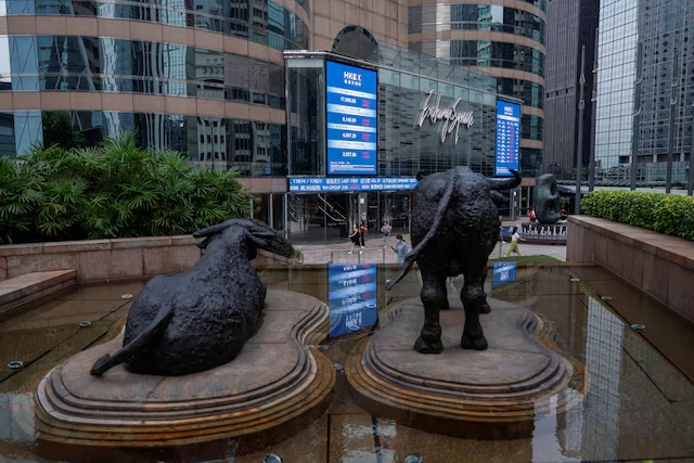 Bull statues are placed in font of screens showing the Hang Seng stock index and stock prices outside Exchange Square, in Hong Kong, China, August 18, 2023. REUTERS/Tyrone Siu/File Photo 