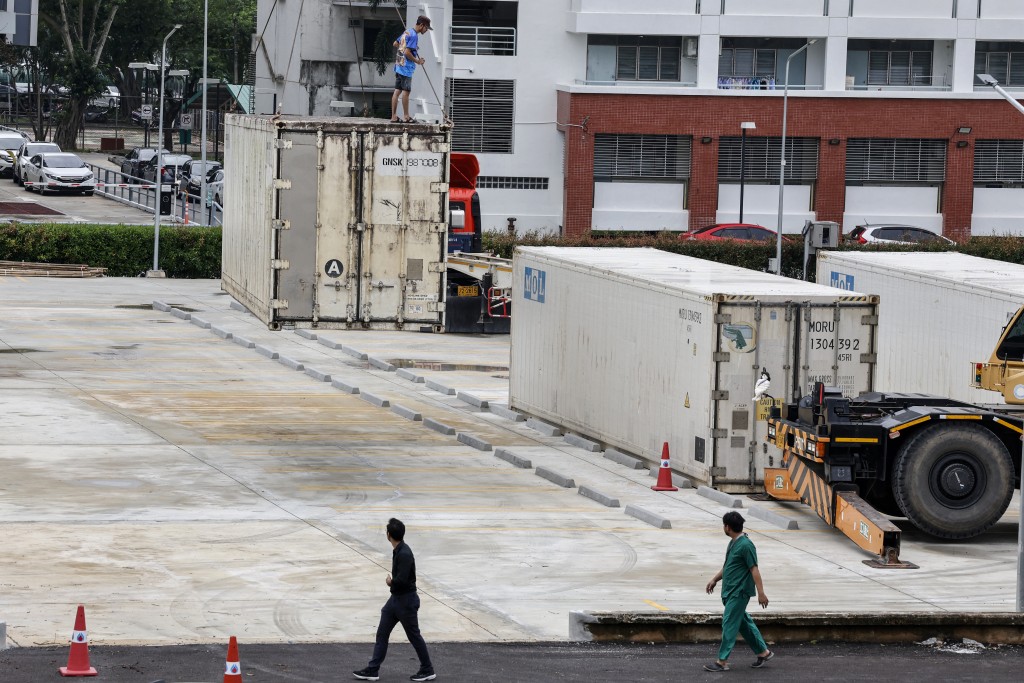 Photo by SAROT MEKSOPHAWANNAKUL / THAI NEWS PIX / AFP  Refrigerated containers are installed to store the bodies of flood victims outside Songklanagarind Hospital in Hat Yai in Thailand's southern Songkhla province on November 28, 2025, as severe flooding affected thousands of people in the country's south following days of heavy rain.