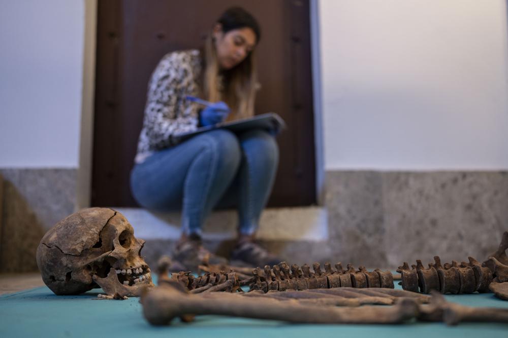 Forensic Flavia Teixeira works next to a skull of a victim after an exhumation inside a mass grave at an excavation of A.R.M.H., Association for the Recovery of Historical Memory at the cemetery in Guadalajara, Spain. (AP) Forensic Flavia Teixeira works next to a skull of a victim after an exhumation inside a mass grave at an excavation of A.R.M.H., Association for the Recovery of Historical Memory at the cemetery in Guadalajara, Spain. (AP)
