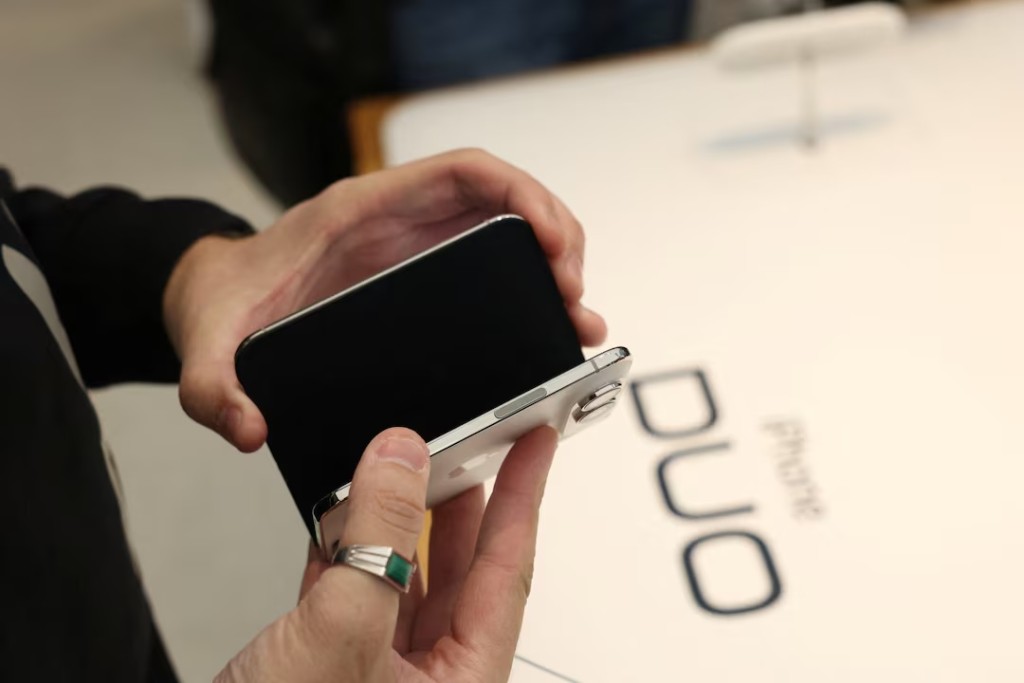 A customer holds an Apple iPhone Duo during Apple’s Sydney launch of its first folding phone, in Sydney, Australia, October 23, 2026. REUTERS/Hollie Adams