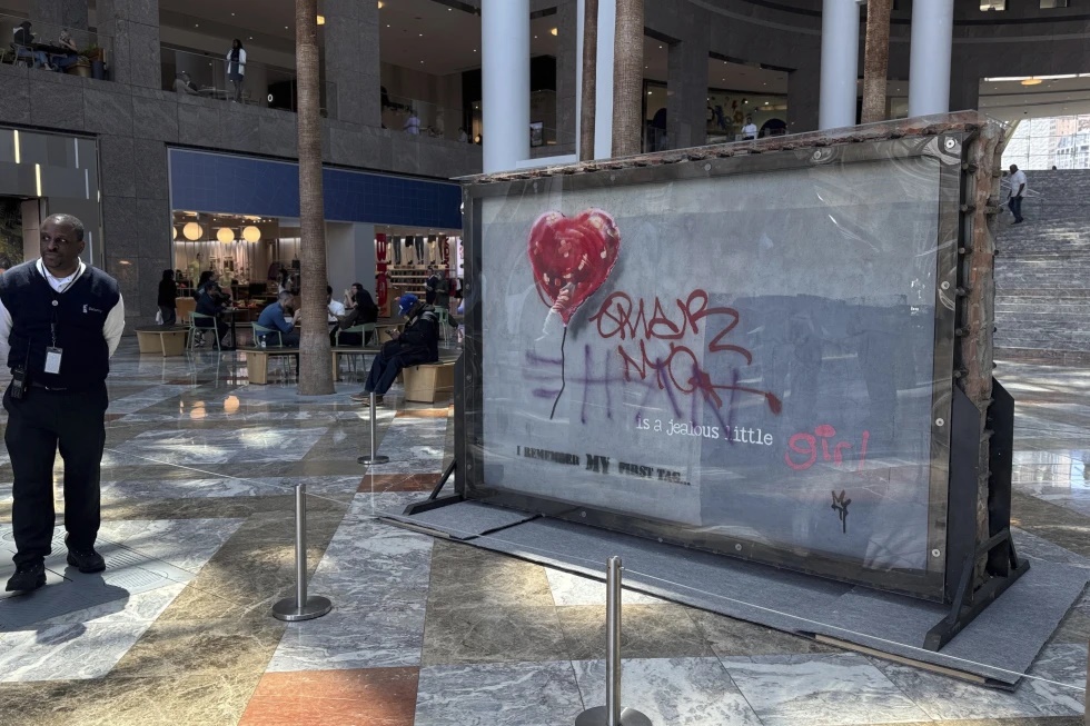 A slab of wall art, The “Battle to Survive a Broken Heart,’ created by the artist Banksy, sits on display inside the Brookfield Place atrium, Tuesday, April 29, 2025, in New York. The nearly four-ton piece will be auctioned off on May 21. (AP Photo/Julie Jacobson)