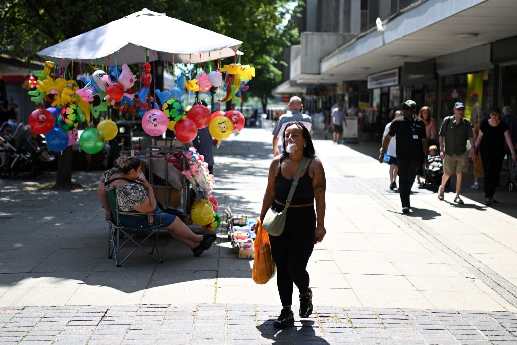 Photo by OLI SCARFF / AFP A person Vapes in the town centre in Huddersfield, northern England on June 23, 2026. Multiple schools in England shut early on June 23 and set to remain closed for two more days with a heatwave expected to set new records in the UK as it spreads across Europe.