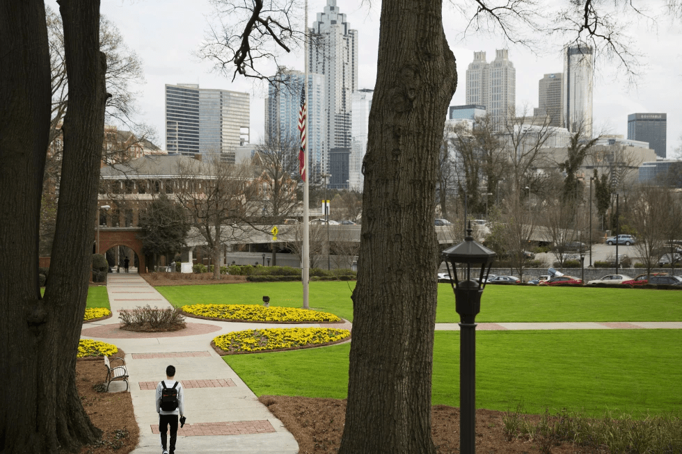 A person walks through the Georgia Tech campus with the downtown skyline in the background, March 11, 2016, in Atlanta. (AP Photo/David Goldman, File)