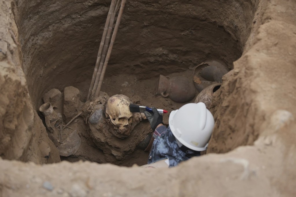 Archaeologist Jose Aliaga works at the site where city workers discovered ancient remains, from the pre-Inca Chancay culture, and artifacts as workers were digging a natural gas line for the company Calidda in the district of Puente Piedra on the outskirts of Lima, Peru, Thursday, July 31, 2025. (AP Photo/Guadalupe Pardo)