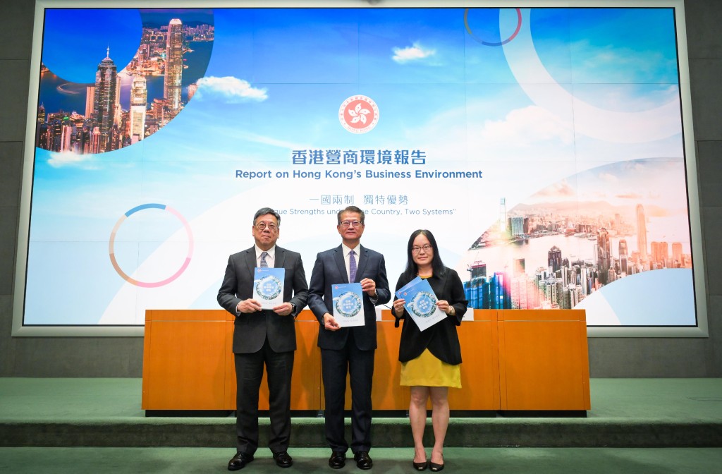 Financial Secretary Paul Chan, center, Secretary for Commerce and Economic Development Algernon Yau, and acting government economist Cecilia Lam show off the report. (GIS)