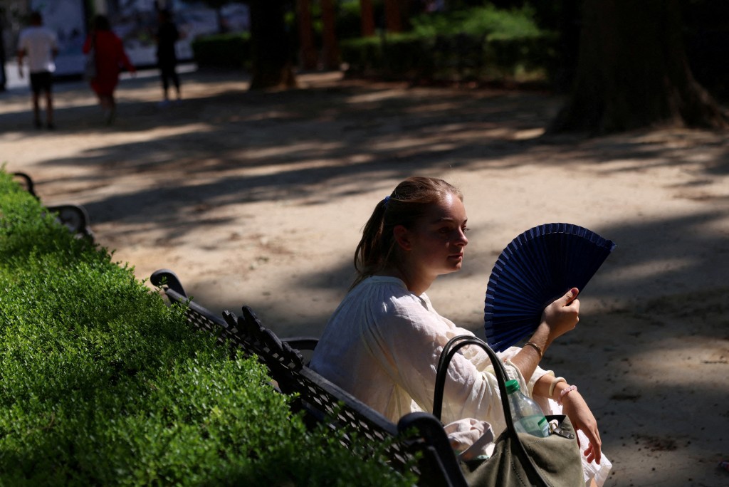A woman uses a fan during a heatwave, in Seville, Spain, July 2, 2025. (Reuters)