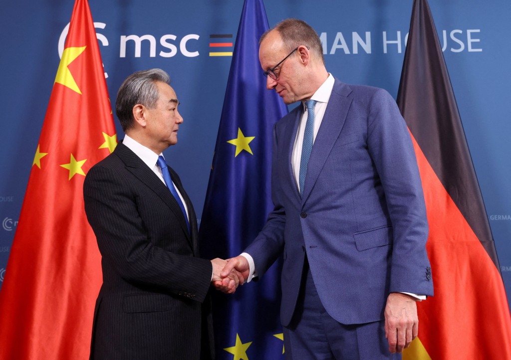 German Chancellor Friedrich Merz and Chinese Foreign Minister Wang Yi shake hands prior bilateral talks during the 62nd Munich Security Conference (MSC) on February 14, 2026 in Munich, southern Germany. (AFP)