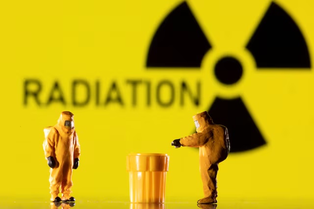 Figurines in protective equipments are seen in front of a displayed 'Radiation' sign in this illustration taken March 9, 2022. REUTERS/Dado Ruvic/Illustration