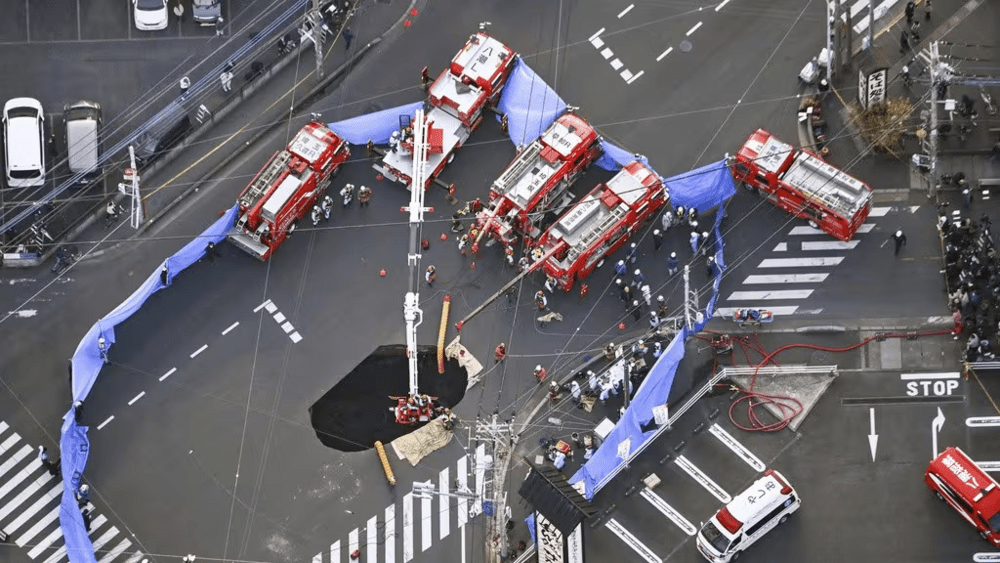First responders try to rescue the driver of a truck that fell into a sinkhole on a street in Yashio, northeast of Tokyo. (Source: Associated Press) First responders try to rescue the driver of a truck that fell into a sinkhole on a street in Yashio, northeast of Tokyo. (Source: Associated Press)