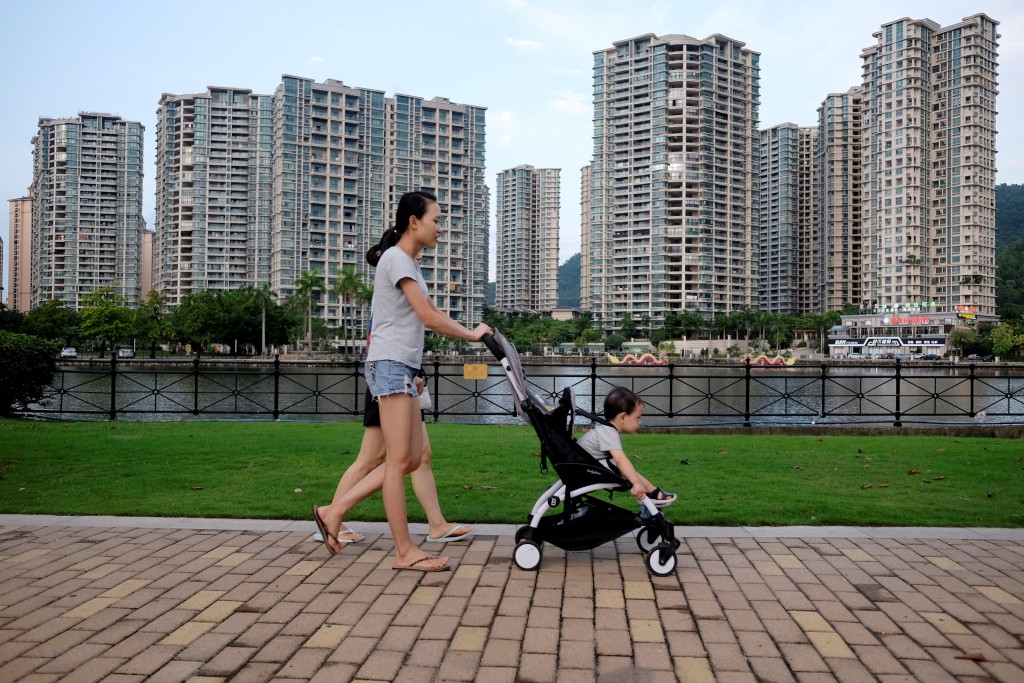 People walk past a residential property development by Agile Property in Zhongshan, China, June 27, 2018. REUTERS