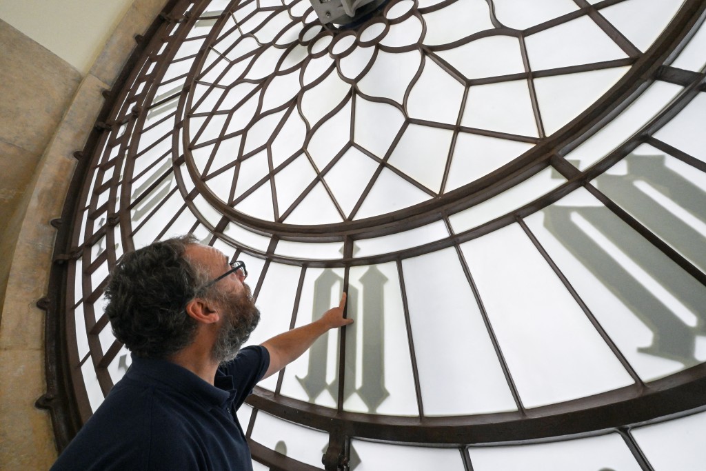 Photo by JUSTIN TALLIS / AFP  Clock mechanic Huw Smith inspects the internal side of the clock face, inside the Elizabeth Tower, commonly known by the name of the clock's largest bell, Big Ben, in the Houses of Parliament in London on October 22, 2025.